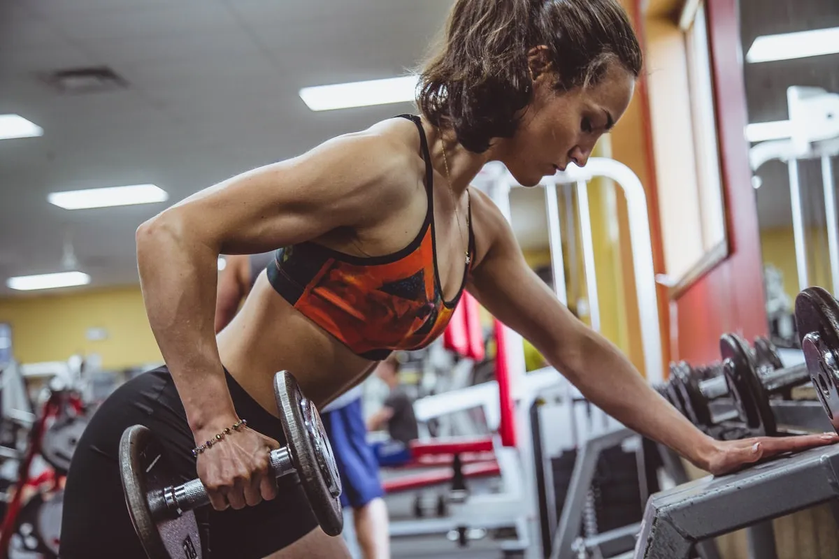 Femme en fitness avec une whey isolate — profil calorique lean idéal pour la sèche, le maintien du poids et la récupération musculaire sans prise de masse indésirable