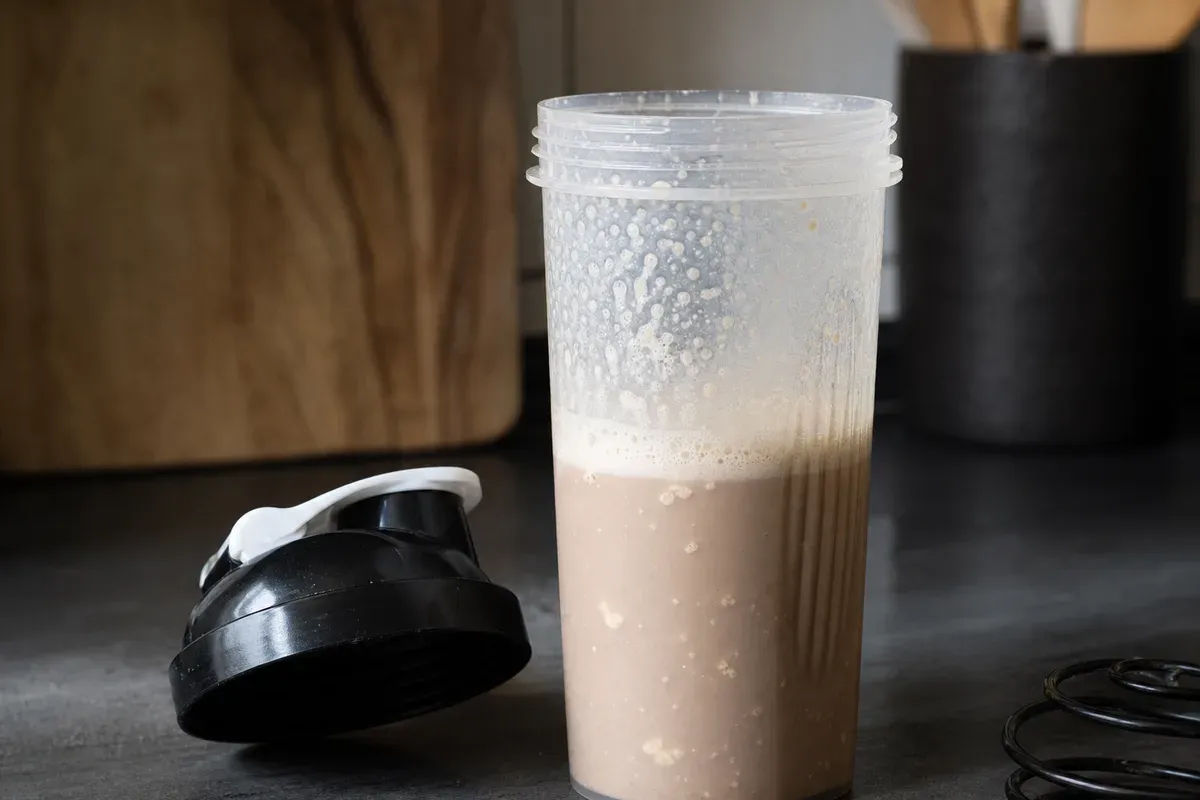 Shaker gradué avec Whey Bio Native Alter Nutrition — test de miscibilité à l'eau froide, mousse résiduelle mesurée à 30 secondes